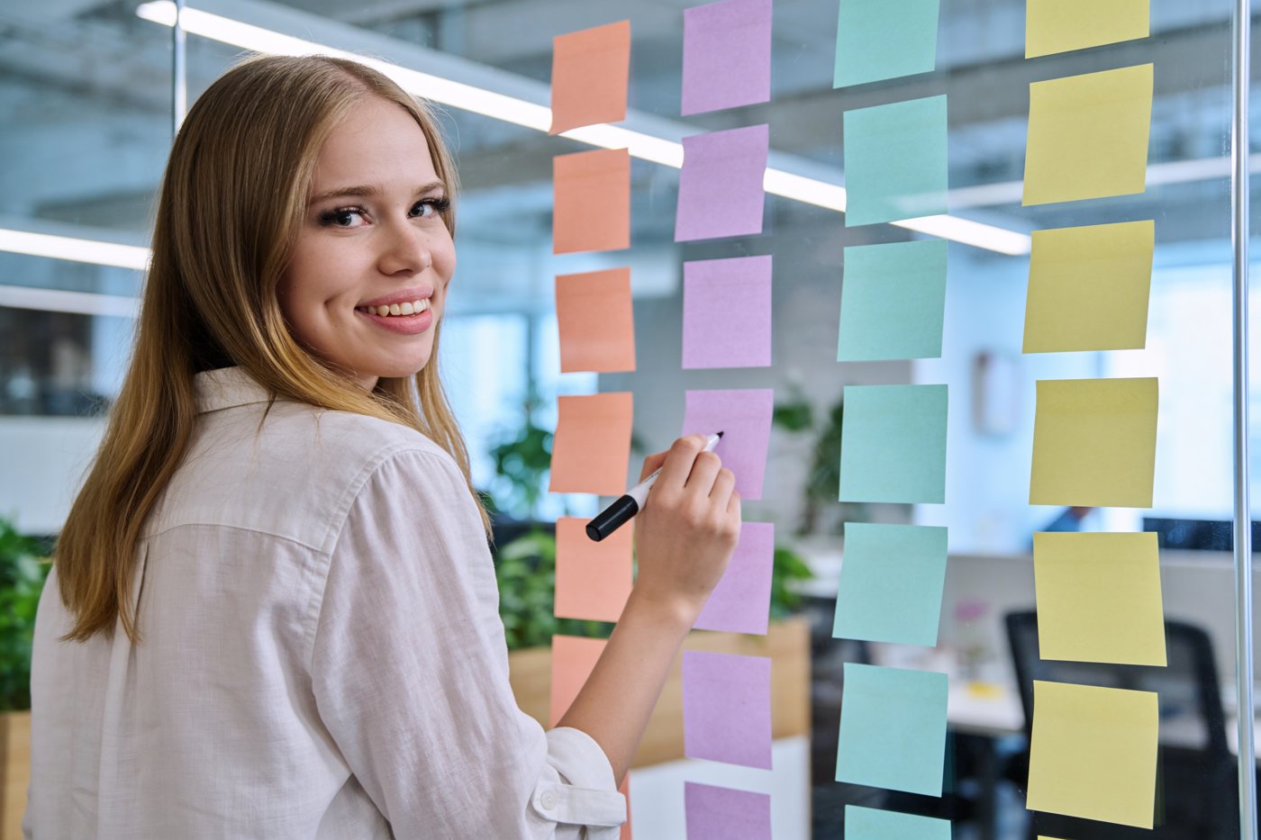 Eva plant einen Launch an einer Wand voller Haftnotizen
